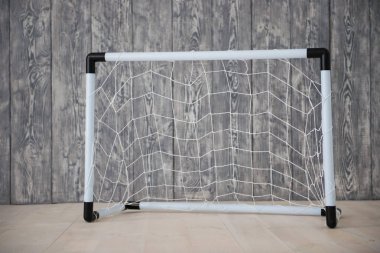Gri bir arka plan üzerinde küçük bir kapı bir futbol topu. Mini Futbol.