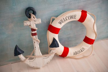 Bir çapa ve lifebuoy mavi bir duvar ile deniz konulu bir kompozisyon