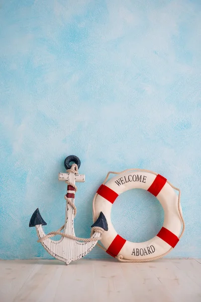 Композиция на морскую тему с якорем и спасательным буем на синей стене — стоковое фото