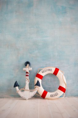 Bir çapa ve lifebuoy mavi bir duvar ile deniz konulu bir kompozisyon
