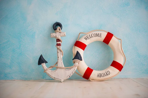 Una composición sobre un tema del mar con un ancla y boya de vida en una pared azul — Foto de Stock