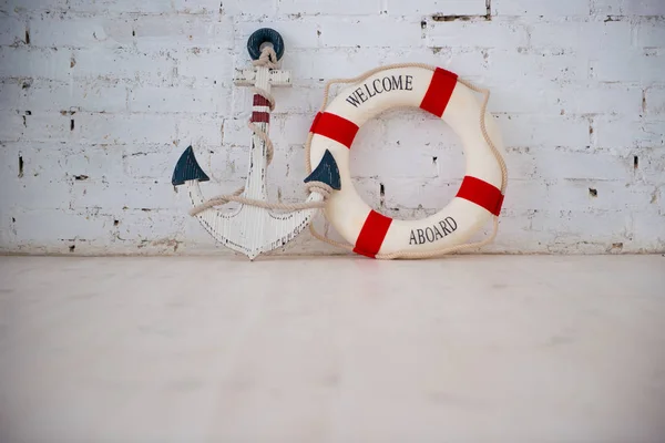 흰색 벽돌 벽에 앵커와 생활 반지와 바다 테마 구성. — 스톡 사진