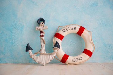 Bir çapa ve lifebuoy mavi bir duvar ile deniz konulu bir kompozisyon