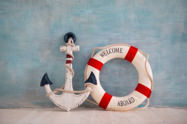 Bir çapa ve lifebuoy mavi bir duvar ile deniz konulu bir kompozisyon