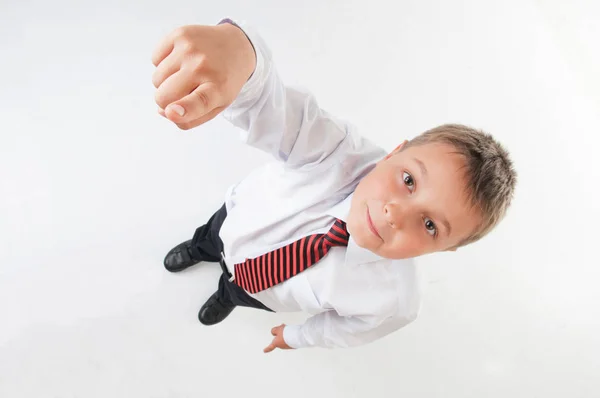 Carino adolescente ragazzo in bianco camicia e cravatta puntando con il dito su un bianco isolato sfondo . — Foto Stock