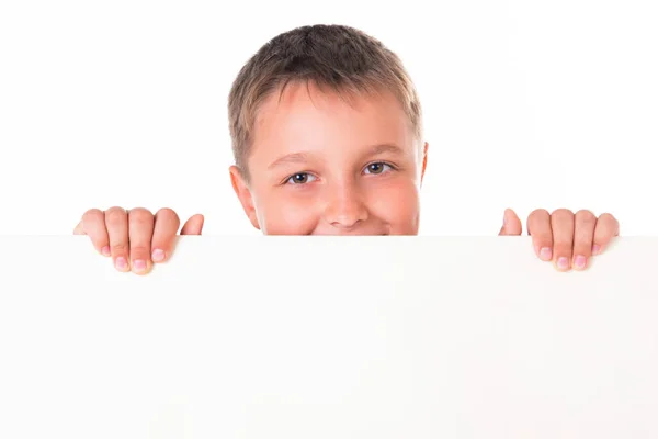 Un bel maschio sorridente posa dietro un pannello bianco isolato su sfondo bianco — Foto Stock