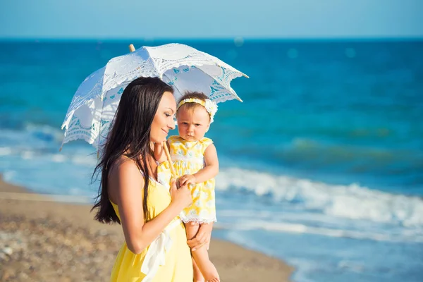 Anne ile kızı sıcak bir günde bir beyaz dantel şemsiyesi altında — Stok fotoğraf