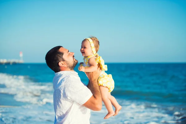 Glücklicher Vater spielt mit süßer kleiner Tochter am Strand — Stockfoto