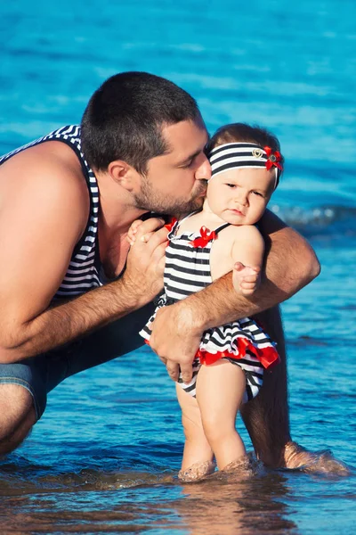 Šťastný otec hraje s roztomilá malá dcera na pláži — Stock fotografie