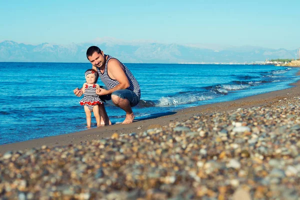Щасливий батько грає з милою маленькою донькою на пляжі — стокове фото
