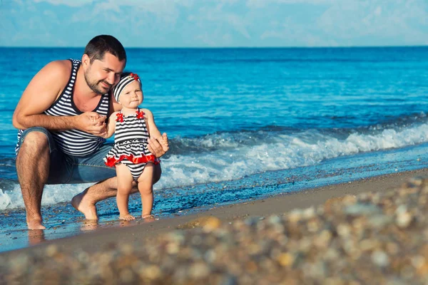 Glücklicher Vater spielt mit süßer kleiner Tochter am Strand — Stockfoto