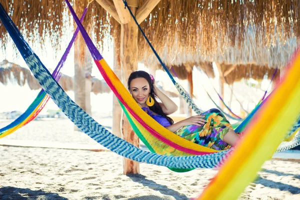 Muchacha joven alegre bastante asombrosa en la playa, acostada en una hamaca y sonriendo en un bikini sexy negro en un sombrero de lujo ancho y gafas de sol espejadas son palmeras reflejadas, estilo de vida, bronceado — Foto de Stock