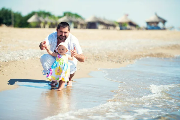 Glücklicher Vater und seine süße kleine Tochter am Strand — Stockfoto