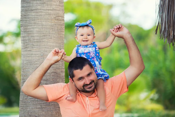 Beautiful little girl is sitting with her dad on her neck — Stock Photo, Image