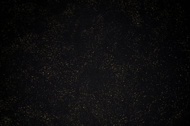 Siyah arka planda altın rengi parıltı dokusu. Tatil geçmişi. Altın konfeti patlaması. Siyah arkaplandaki altın taneli soyut doku. Tasarım ögesi.