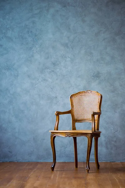 Alter Stuhl auf grauem Wandhintergrund. — Stockfoto