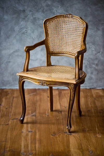 Alter Stuhl auf grauem Wandhintergrund. — Stockfoto