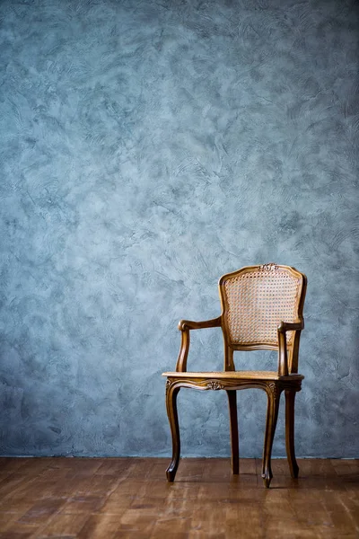 Vieille chaise sur un fond mural gris . — Photo