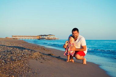 Küçük, tatlı kızınızı da kumsalda oynarken mutlu baba