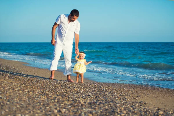 Glückliche Familie, Vater mit Tochter am Strand, lernt laufen. — Stockfoto