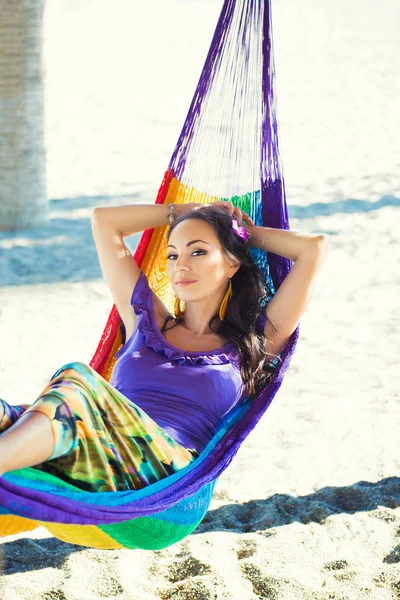 Muchacha joven alegre bastante sorprendida en la playa, sonriendo miente en una hamaca contra el telón de fondo de palmeras, estilo de vida, bronceado. Recreación — Foto de Stock