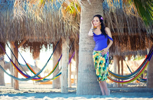 Jovencita alegre bastante sorprendida en la playa sonriendo en un fondo de palmas y hamacas, estilo de vida, bronceada — Foto de Stock