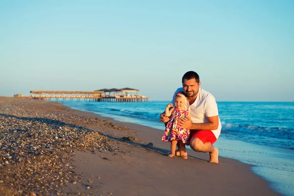 Pai feliz brincando com a filhinha fofa na praia — Fotografia de Stock