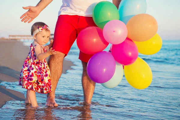 Pai e filha com balões brincando na praia no dia. Conceito de família amigável . — Fotografia de Stock