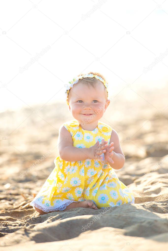 Lovely little girl on the beach with an umbrella