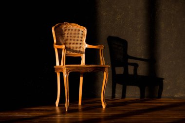 Siyah duvar arka plan üzerinde eski sandalye.