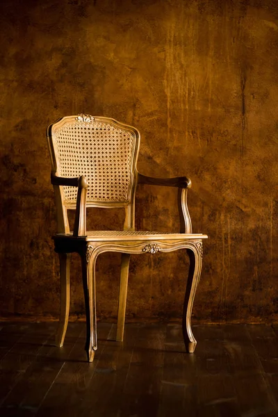 Vieille chaise sur un fond mural brun . — Photo