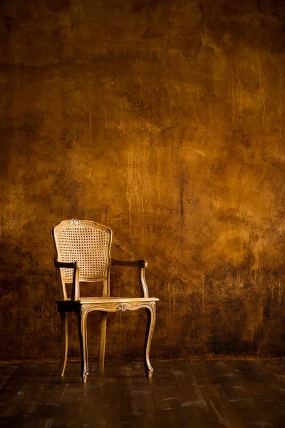 Vieille chaise sur un fond mural brun . — Photo