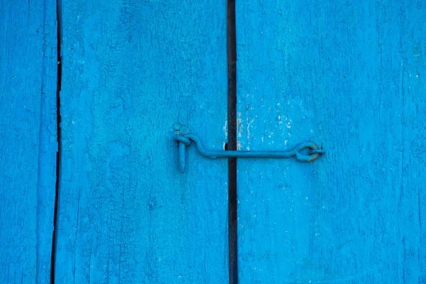 Stare drzwi niebieski jest zamknięta na haku. Tło i tekstura Stare drzwi drewniane — Zdjęcie stockowe