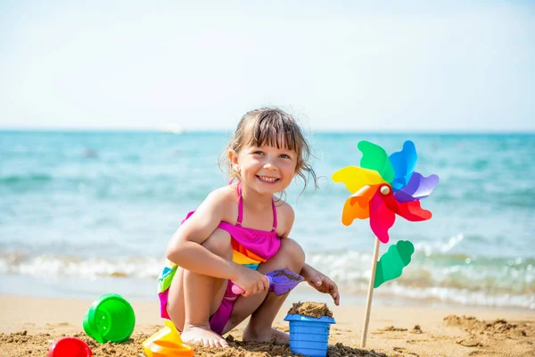 Uśmiechnięta Pozytywna Dziewczynka Latka Wielobarwnym Stroju Kąpielowym Tęcza Ręku Piaszczystej — Zdjęcie stockowe