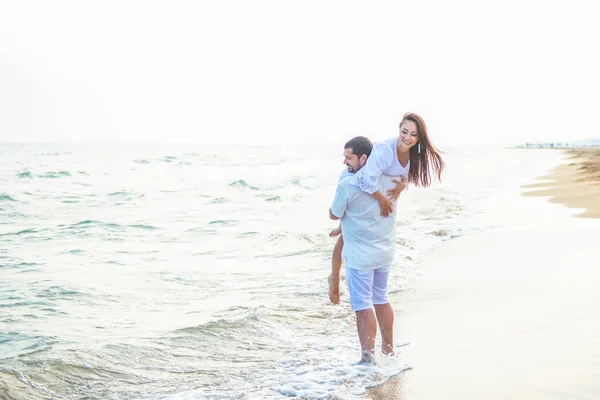 彼女の夫に乗って 海の海岸で楽しさと愚かさを持つ愛の新婚夫婦 — ストック写真