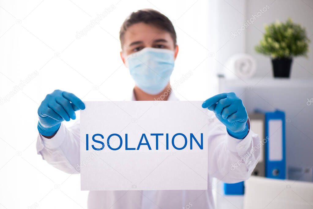 A doctor in a medical gown and protective mask holds a sign that says Insulation. World coronavirus epidemic covid-19, pandemic 2020.