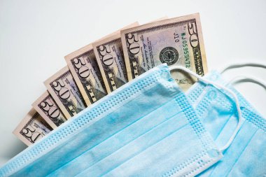 Dolar banknotları olan koruyucu yüz maskeleri. Spekülasyon ve artan ilaç fiyatları. İnsanların sağlığı için iş. COVID 19 Coronavirüs.