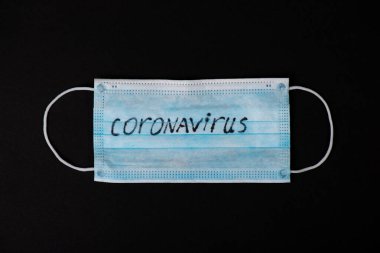 Panik Covid-19 Coronavirüs salgını konsepti. Siyah arka planda Coronavirus koruyucu cerrahi maske.