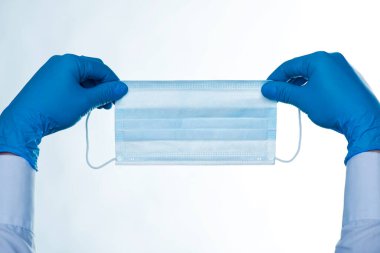 Cerrahi maske tutan lastik eldivenli eller. Beyaz arka planda izole edilmiş. COVID 19 Coronavirüs.