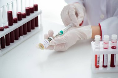 Kan örneği Covid-19 Coronavirus olan test tüpleri. Aşı ve şırınga enjeksiyonu COVID 'den korunma, aşılama ve tedavi için kullanılır.