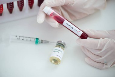 Kan örneği Covid-19 Coronavirus olan test tüpleri. Aşı ve şırınga enjeksiyonu COVID 'den korunma, aşılama ve tedavi için kullanılır.