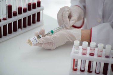 Kan örneği Covid-19 Coronavirus olan test tüpleri. Aşı ve şırınga enjeksiyonu COVID 'den korunma, aşılama ve tedavi için kullanılır.