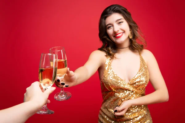 穿着金色连衣裙的性感女人 红色口红 手中拿着香槟 而不是节日的红色背景 新年假期 生日聚会的概念 — 图库照片