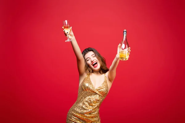 穿着金色连衣裙 头戴红色口红的性感女人喝香槟 与红色背景隔离 新年假期 生日聚会的概念 — 图库照片