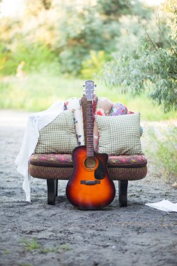 Konum bir koltuk, yastık ve bir gitar