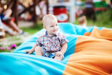  oğlan bir fasulye çanta üzerinde oturuyor