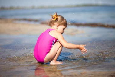Küçük kız sahilde oynuyor