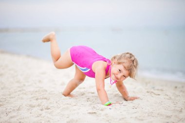 Sahilde çocuk yoga yapan