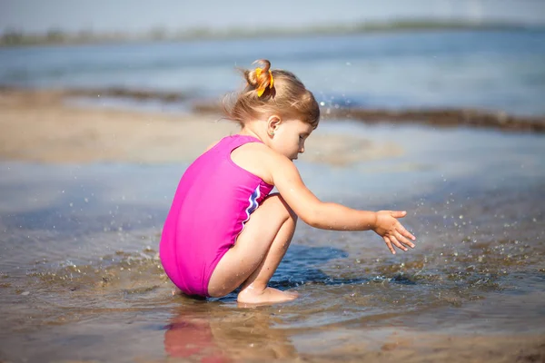 La niña está jugando en la playa. — Foto de Stock