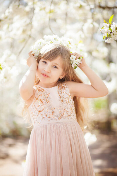 beautiful blonde girl in a blossoming cherry orchard